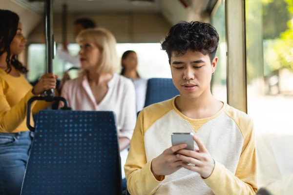 Retrato de cara asiático usando celular em ônibus — Fotografia de Stock