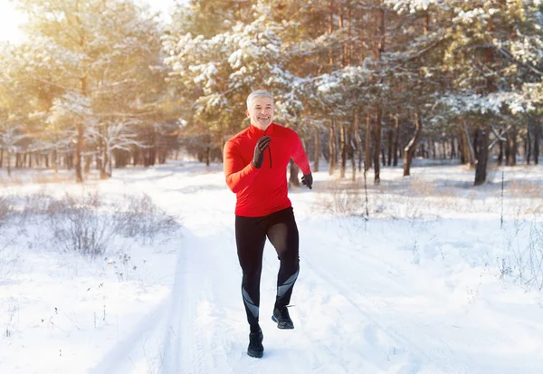 Clima frío corriendo. Retrato de cuerpo entero del hombre maduro en ropa deportiva corriendo en el parque de invierno nevado, espacio para copiar —  Fotos de Stock