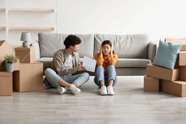 Infelice coppia asiatica che litiga per affitto casa o documenti di acquisto nel loro nuovo appartamento il giorno del trasloco — Foto Stock