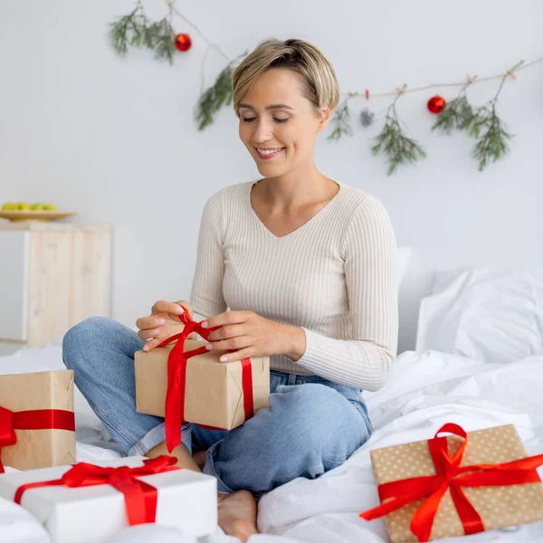 Szczęśliwa pani świętuje świąteczne opakowanie pudełko prezentów — Zdjęcie stockowe
