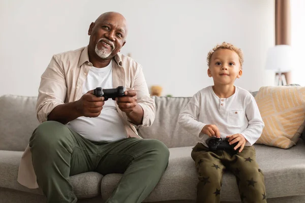 Alegre afro-americano vovô e neto jogar vídeo em casa — Fotografia de Stock