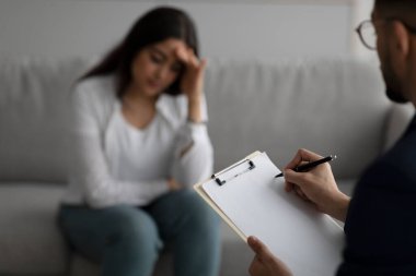 Depresyondaki orta doğulu kadın danışman psikolog, psikiyatristin panoya yazı yazmasına odaklan.
