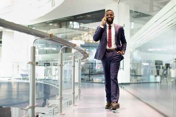 Snygg svart manager promenader vid businesscenter, har telefon konversation — Stockfoto