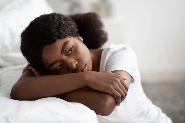 Depressive Afroamerikanerin sitzt zu Hause am Bett, Nahaufnahme — Stockfoto