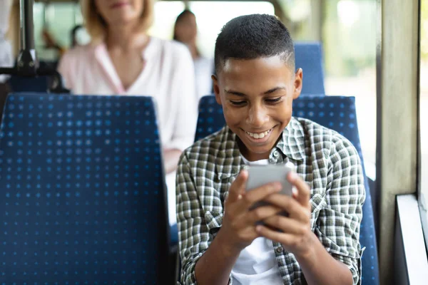 Gelukkig zwart guy met behulp van mobiele telefoon in bus — Stockfoto