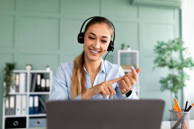 Online eğitim. Genç bayan öğretmen öğrencilerle görüntülü konuşma yapıyor, webcam ile konuşuyor ve açıklama yapıyor.