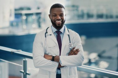 Yakışıklı, gülümseyen Afro-Amerikan doktorun portresi.