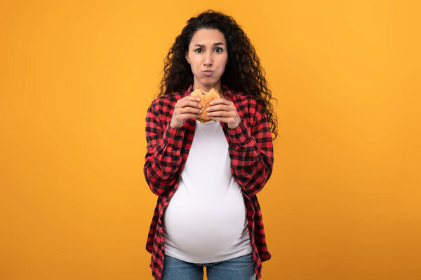 Pregnant Lady Holding Eating Burger At Studio