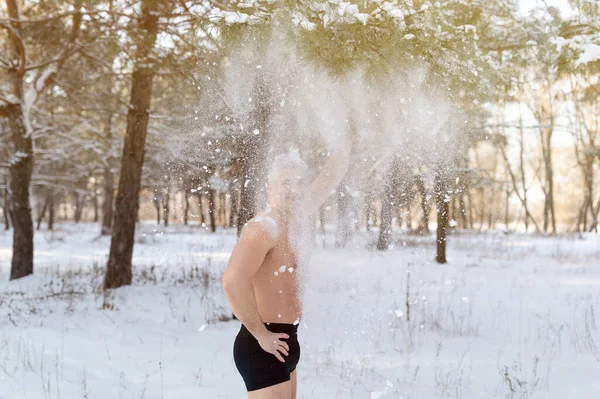 Kış parkında iç çamaşırlı, kendine kar atan mutlu bir adam. Soğuk hava eğitimi ve kış eğlencesi konsepti — Stok fotoğraf