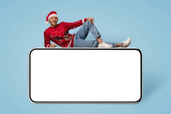 假日酒会。在大块空白智能手机之上躺着快乐的圣诞老人 — 图库照片