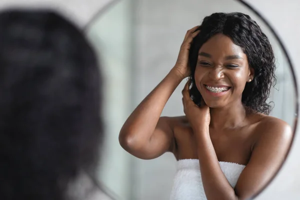 Pretty african american wanita merawat rambut keriting nya — Stok Foto