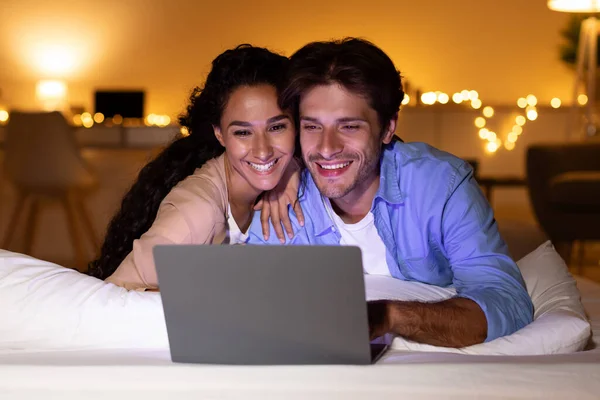 Usmívající se pár pomocí notebooku sledování legrační film v ložnici — Stock fotografie