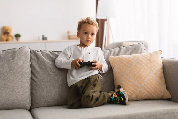 Niño negro jugando videojuegos usando el controlador Gamepad en casa — Foto de Stock