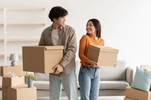 Concept de déménagement. positif jeune asiatique couple portant des boîtes en carton dans leur propre maison — Photo