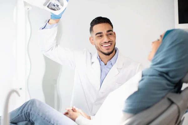 Zahnbehandlung. Zahnärztin aus dem Nahen Osten untersucht muslimische Patientin — Stockfoto