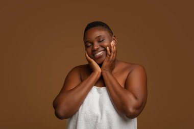 Stüdyoda poz veren güzel, iri yarı Afrikalı Amerikalı bir kadın.