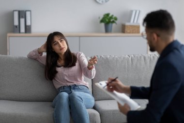 Stresli ve üzgün Arap kadın depresyondan muzdarip. Tıp bürosunda psikologla konuşuyor.