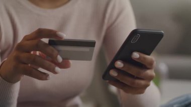 Tanımlanamayan Afro-Amerikan bayan mobil uygulama üzerinden alışveriş yapıyor, akıllı telefondan kredi kartından kişisel verileri giriyor.