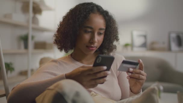 Online winkelen. Jonge Afrikaans-Amerikaanse vrouw het maken van financiële transactie op de smartphone via credit card en mobiele app — Stockvideo