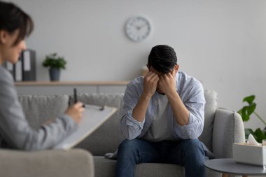 Psikoterapi, depresyon tedavisi. Stresli Ortadoğulu adam psikolog muayenehanesinde.