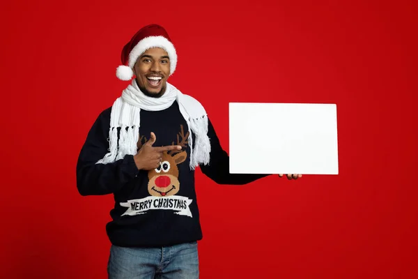 Noel Baba şapkalı pozitif siyah adam elinde boş reklam panosu tutuyor. — Stok fotoğraf