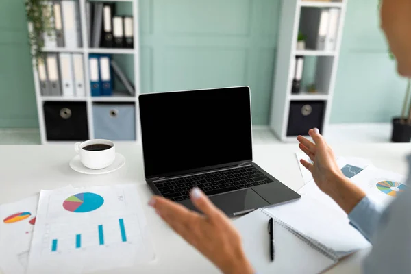 Distnat werk. Jonge zakenvrouw met behulp van laptop met leeg scherm, het maken van videogesprek, werken in modern kantoor — Stockfoto