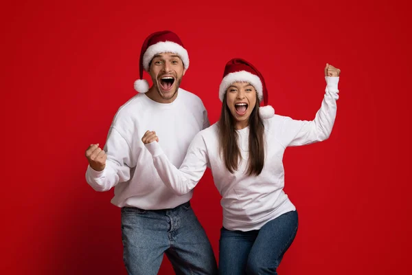 Різдвяна радість. Весела емоційна пара в Санта капелюхах — стокове фото