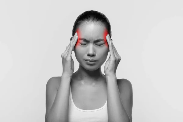 Femme asiatique souffrant de maux de tête, toucher ses tempes — Photo