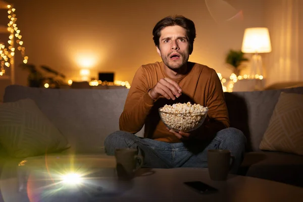 Shocked Man Watching Movie Using Domestic Cinema Projector At Home