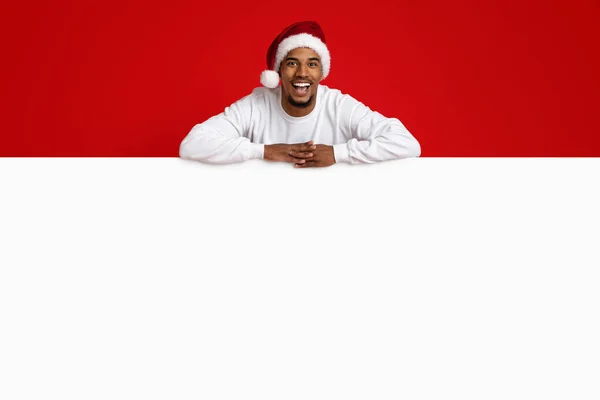 Веселий чорний хлопець Санта Клаус спирається на порожню рекламну дошку. — стокове фото