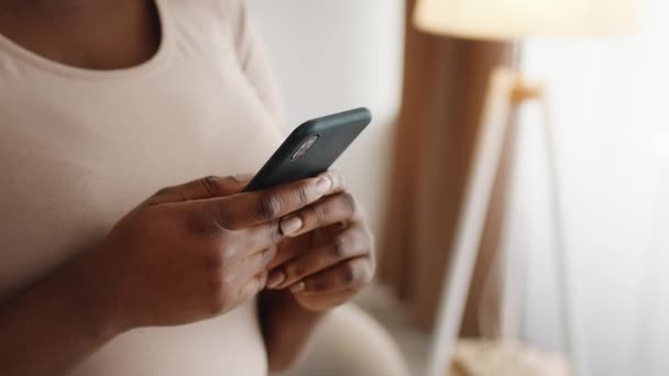 Recadrée prise de vue de dame noire en utilisant Smartphone SMS debout à l'intérieur — Video