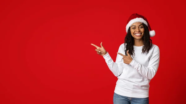 Positivo giovane signora nera in cappello Babbo Natale che mostra spazio copia — Foto Stock