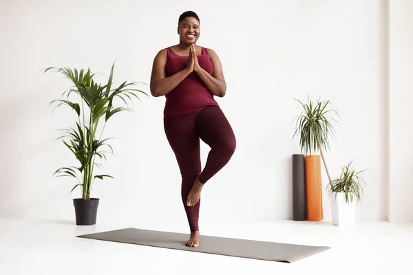 Alegre gordito negro mujer haciendo yoga en gimnasio —  Fotos de Stock