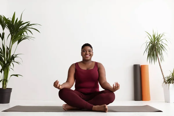 Feliz más tamaño mujer negra haciendo ejercicio de yoga en el estudio —  Fotos de Stock