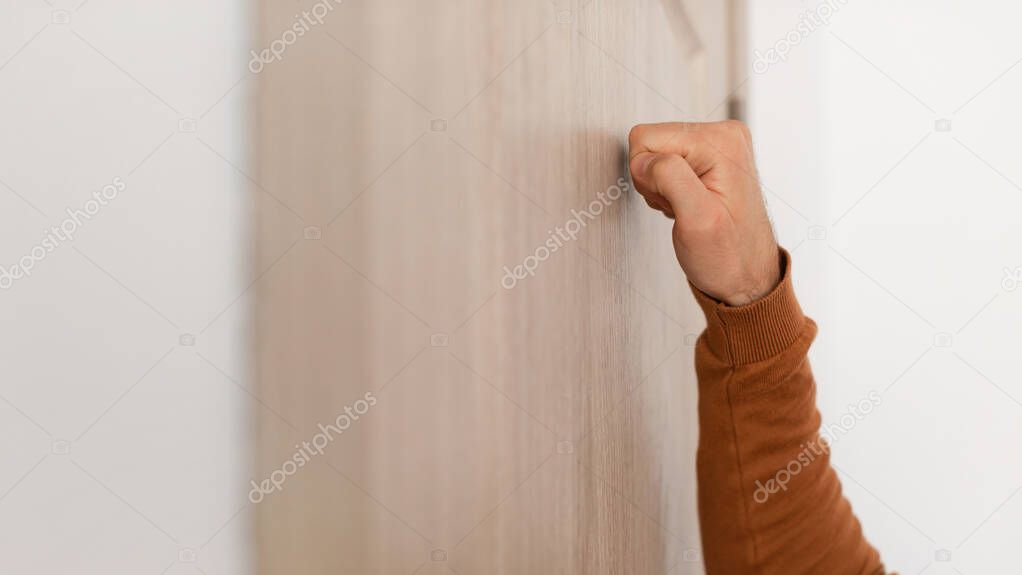 Closeup of man knocking on the wooden door