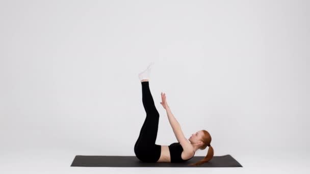 Atletisch jong vrouw maken snoek Crunch oefening op fitness mat in studio — Stockvideo