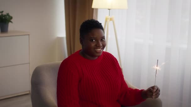 Glad svart kvinna brännande gnistrar firar nyår hemma — Stockvideo