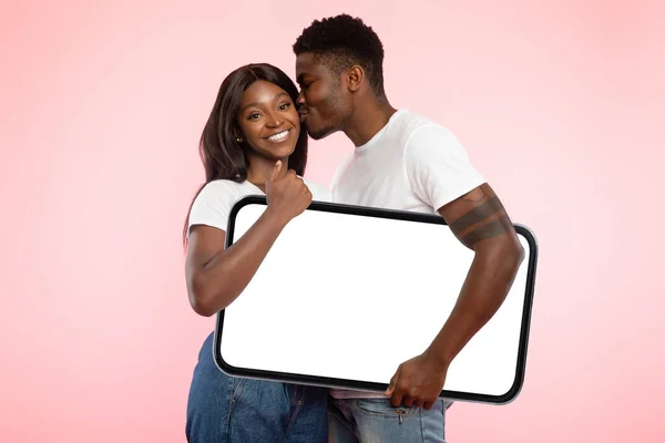 Nero coppia tenendo vuoto bianco telefono schermo e baci — Foto Stock