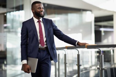 Mutlu Afro-Amerikan iş adamı dizüstü bilgisayarı ile ofis binasında