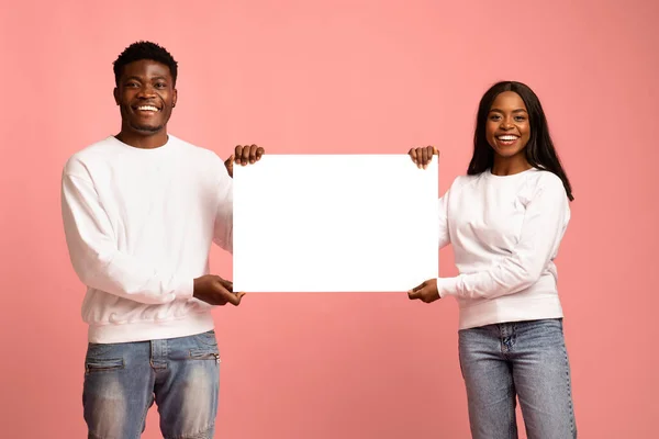 Cheerful black couple showing empty placard for advertisement — Stockfoto