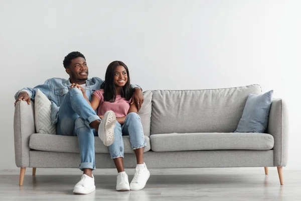 Feliz negro pareja pasando fin de semana juntos sentado en sofá — Foto de Stock