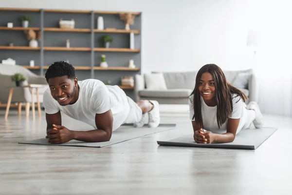 Young black couple planking together in living room — Stock Photo, Image