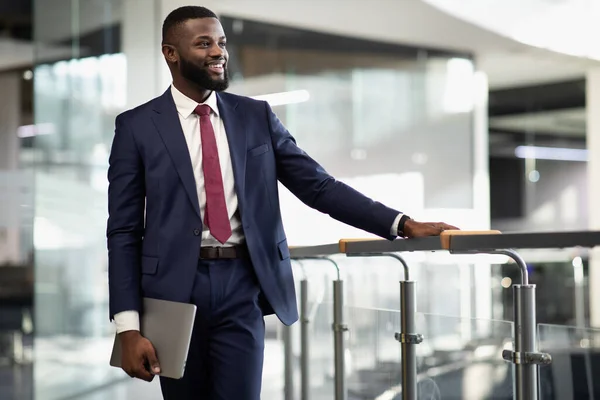 Feliz hombre de negocios afroamericano con portátil en el edificio de oficinas — Foto de Stock