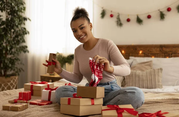 Anno nuovo e celebrazione di Natale. Felice donna afro-americana che riceve il regalo di Natale e tiene i calzini carini — Foto Stock