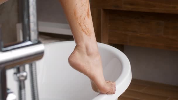 Концепция ухода за телом. Крупный план неузнаваемой женщины, чистящей ноги в ванной — стоковое видео