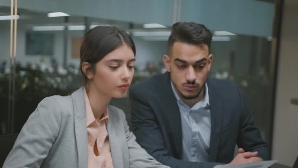 Business analytics concept. Young professional multiethnic coworkers reading financial reports and graphs at office — Stockvideo