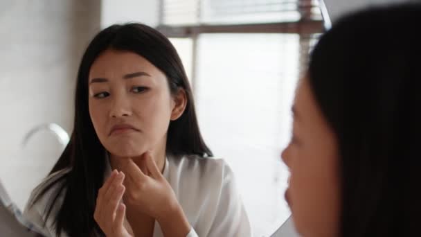 Ongelukkig japans vrouw aanraken hals huid met tweede kin Indoor — Stockvideo