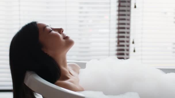 Japonais dame baignade avec mousse couché dans la baignoire dans la salle de bain — Video