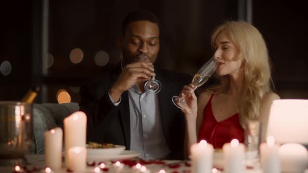 Різноманітна пара пити ігристе вино насолоджуючись романтичне побачення в ресторані — стокове відео