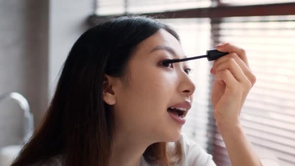 Täglich Make-up. Hübsch asiatisch weiblich getting ready im badezimmer, applizieren mascara — Stockvideo